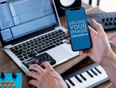 iPhone 11 Pro Mockup of a Man Making Music at His Home Studio