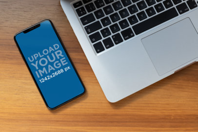 iPhone 11 Pro Max Mockup Featuring a Laptop over a Wooden Surface