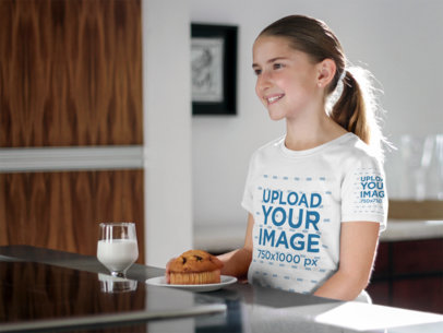 T-Shirt Mockup Featuring a Young Girl Having Breakfast