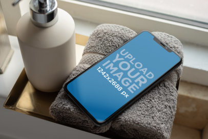 iPhone XS Max Mockup Resting over a Towel in a Bathroom 25895