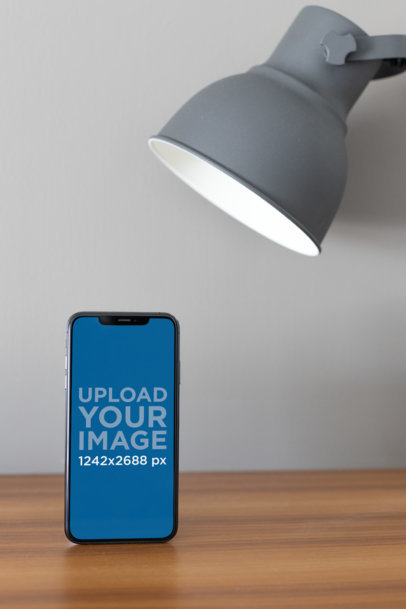 iPhone 11 Pro Max Mockup Standing Under a Desk Lamp