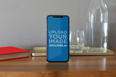 iPhone XS Max Mockup Standing Next to Some Glass Recipients 25897