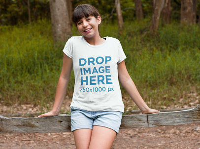 T-Shirt Mockup of a Young Girl Leaning Against a Fence a7969