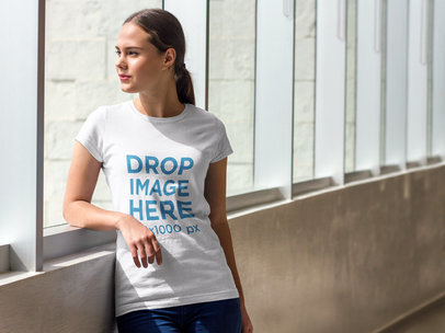 T-Shirt Mockup of a Young Woman Looking Through a Window
