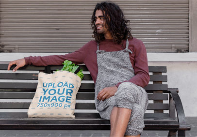 Tote Bag Mockup of a Long-Haired Man Sitting on a Bench