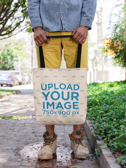 Mockup of a Man with Distressed Shoes Holding a Tote Bag on a Street Puddle