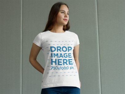 T-Shirt Mockup of a Woman Standing in Front of a Wall