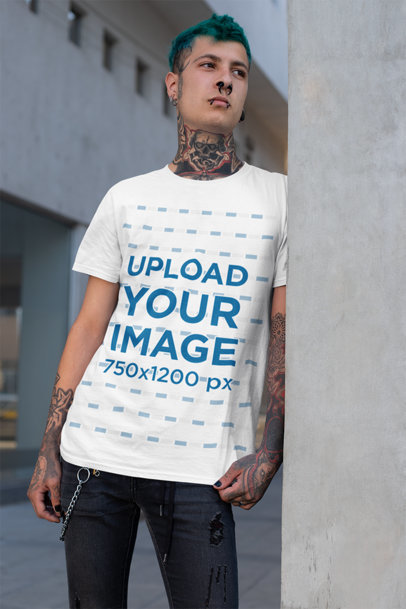 T-Shirt Mockup Featuring a Tattooed Man Leaning over a Concrete Wall