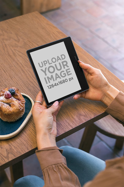 Kindle Mockup Featuring a Woman Reading at a Cafe