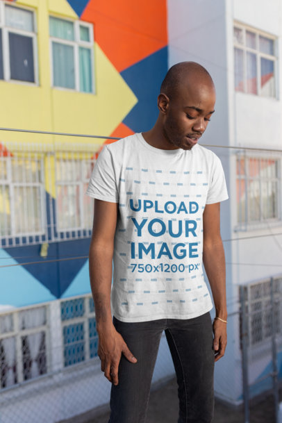 Mockup of a Man Wearing a Tee in Front of Graffiti Art 