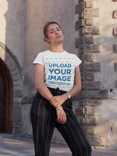 Tee Mockup of a Blonde Woman Posing by an Old Architecture Building