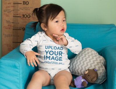 Onesie Mockup of a Baby Girl Sitting on a Couch