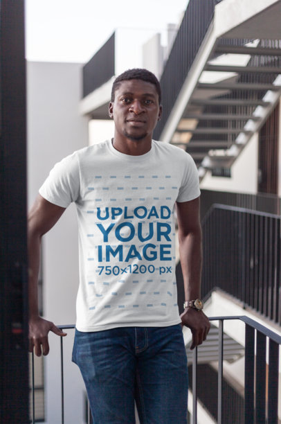 T-Shirt Mockup of a Man Posing Casually in a Building with Stairways