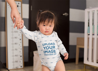 Onesie Mockup of a Baby Girl Holding Her Mom's Hand