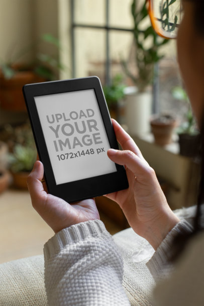 Mockup of a Woman Reading from Her Kindle Paperwhite at Home