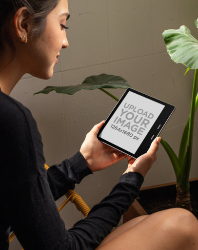 Kindle Oasis Mockup of a Woman Sitting Next to a Plant 