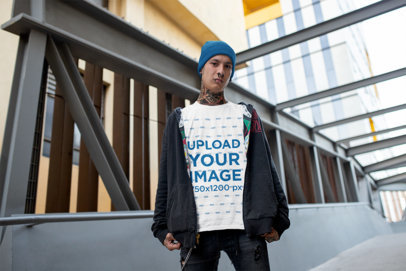 T-Shirt Mockup of an Edgy Man Standing in an Urban Bridge