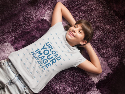 T-Shirt Mockup of a Young Girl Lying on a Rug a7965