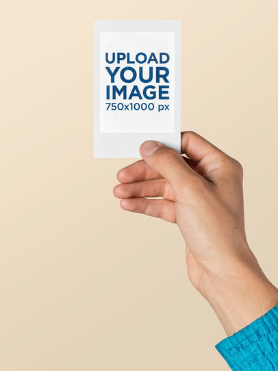 Mockup of a Blue Jacket Person Holding an Instax Picture Frame 26173