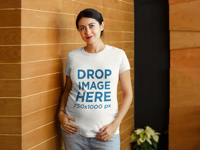 T-Shirt Mockup of a Pregnant Lady Next to a Wooden Wall a7964