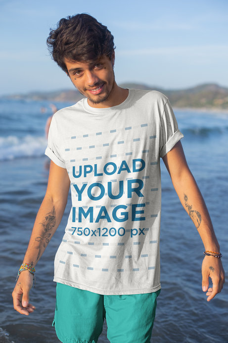 Mockup of a Tattooed Young Man by the Sea Wearing a T-Shirt
