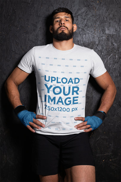 T-Shirt Mockup of an MMA Wrestler Against a Wall