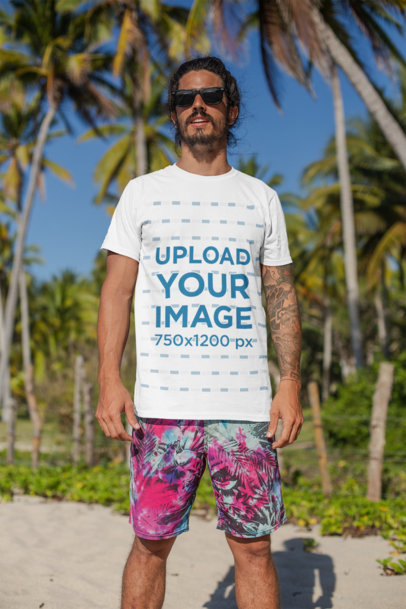 T-Shirt Mockup of a Man with Surfer Shorts Standing at the Beach