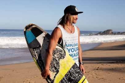 Tank Top Mockup of a Young Man Carrying a Surfboard at the Beach
