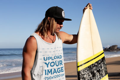 Tank Top Mockup of a Long-Haired Man Beside His Surfboard at the Beach