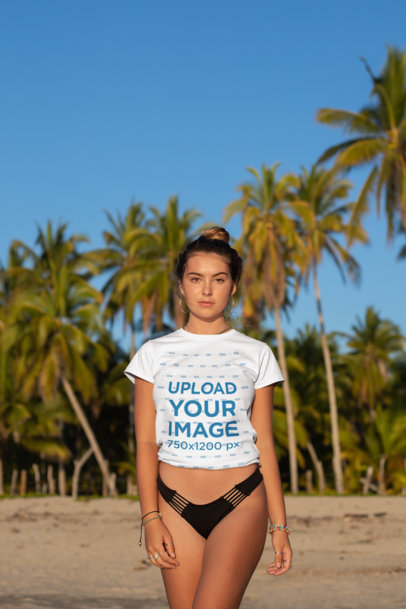 Tee Mockup of a Bronzed Woman by Some Palm Trees at the Beach