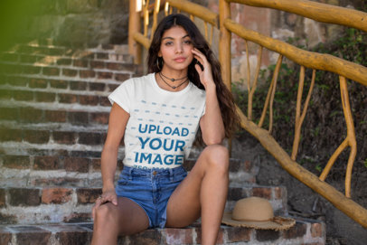 Tee Mockup of a Gorgeous Woman Sitting in a Rustic Stairway