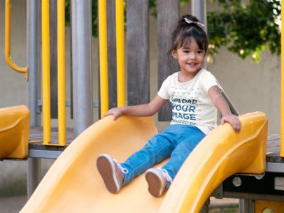 T-Shirt Mockup Featuring a Little Girl on a Slide at a Park
