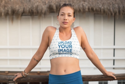 Mockup of a Woman with a Sports Bra and Leggings Leaning over a Wooden Handrail