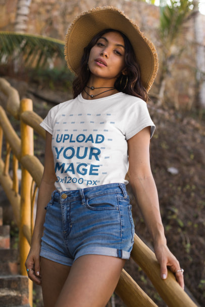 Tee Mockup of a Young Woman with a Floppy Hat on a Staircase