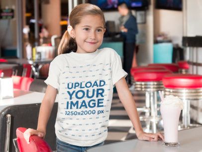 Little Girl at a Diner Having a Milkshake T-Shirt Mockup a8039