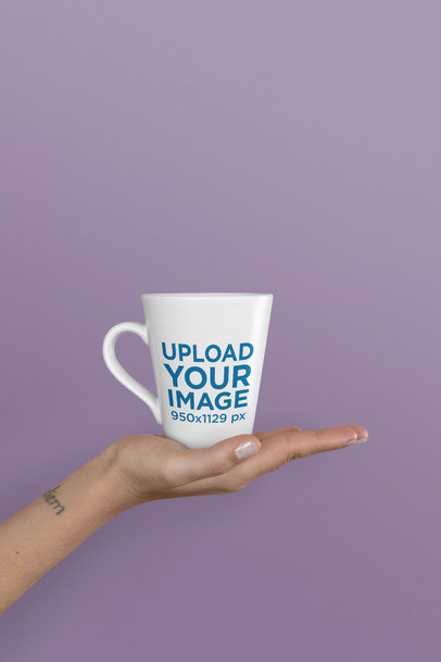 Mockup of an 11 oz Coffee Mug Held Up Against a Solid Background