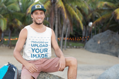 Tank Top Mockup of a Smiling Man with a Cap Sitting on a Rock by Some Palm Trees 26793