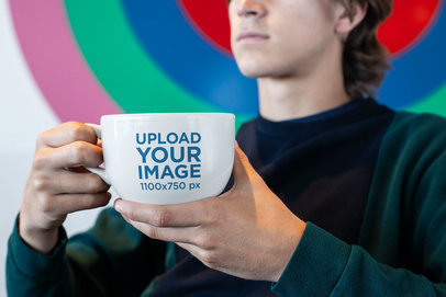 Coffee Mug Mockup of a Man Sitting in Front of a Colorful Wall 26513