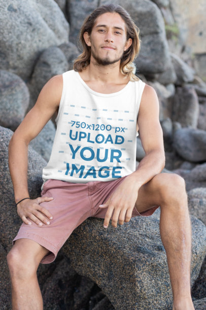 Tank Top Mockup of a Long-Haired Man Sitting over a Breakwater Rock by the Beach 26795