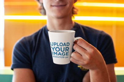 Mockup of a Smiling Young Man Holding an 11 oz Coffee Mug