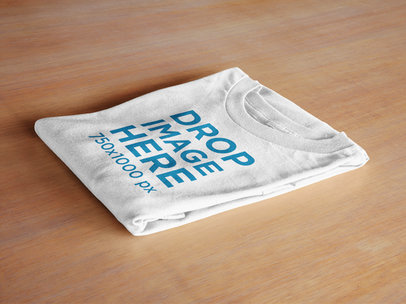 Folded T-Shirt Mockup Lying Over a Table Surface a6480