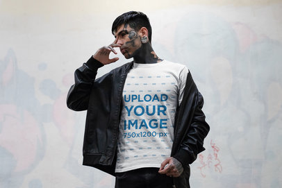 T-Shirt Mockup of a Goth Man with a Face Tattoos Standing by a Graffitied Wall 26602