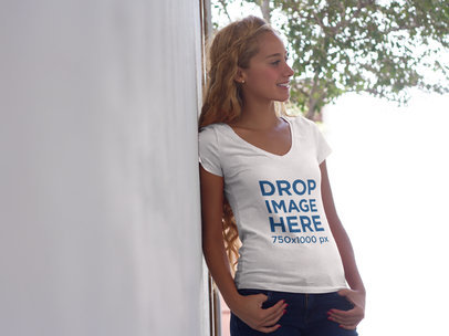 T-Shirt Mockup of a Young Blonde Woman Leaning Against a Wall