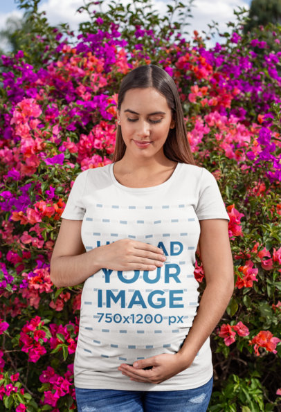 Tee Mockup of a Pregnant Woman Against a Blooming Flower Bush