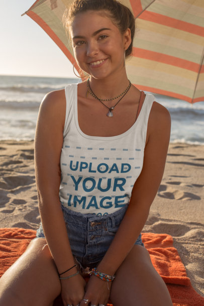 Tank Top Mockup of a Smiling Woman Sitting Under a Beach Parasol 