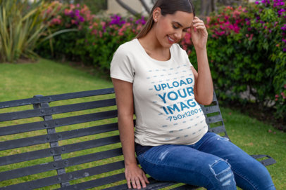 T-Shirt Mockup of a Happy Pregnant Woman Sitting at a Garden