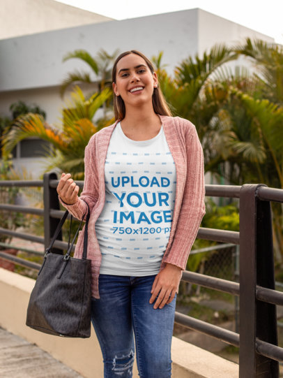 Tee Mockup Featuring a Pregnant Woman Carrying a Bag over a Small Bridge