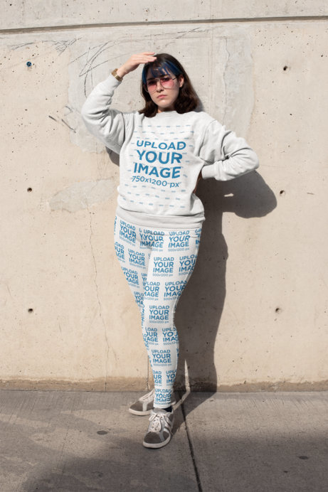 Mockup of a Woman Wearing a Plus Size Sweatshirt and Leggings Covering Her Face from the Sun