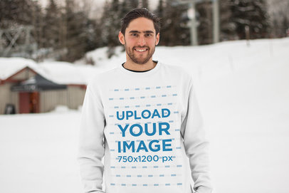 Mockup of a Man with a Beard Wearing a Sweatshirt on a Snowy Mountain