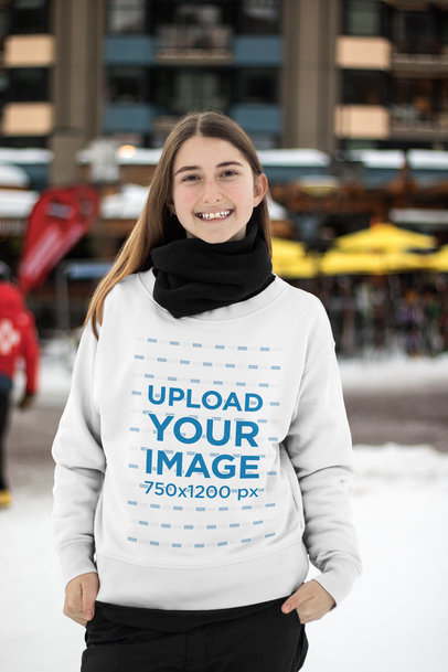 Sweatshirt Mockup of a Smiling Teenager with a Scarf in a Snowy City 25428